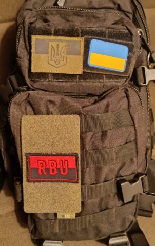 Distintivo vermelho e preto R.B.U (Comum tanto para a comunidade R.B.U - M como para a comunidade R.B.U)